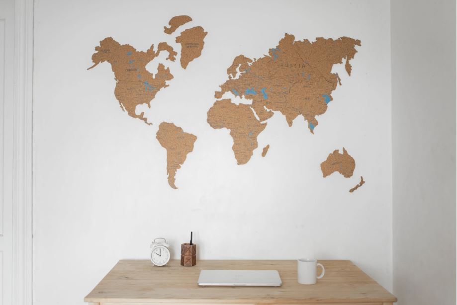A desk with a world map in the wall in front of it