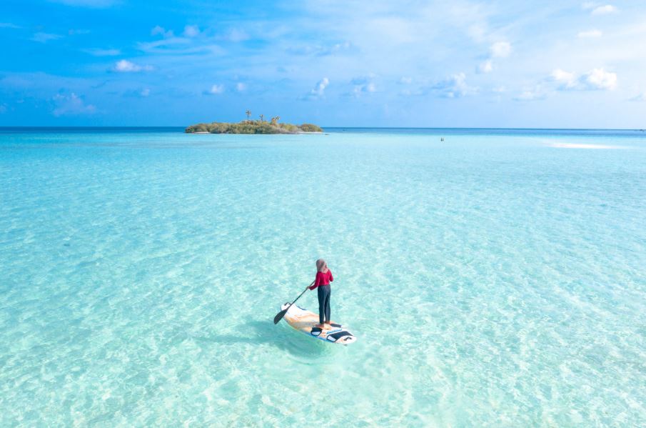 A person paddle boarding in a blue sea