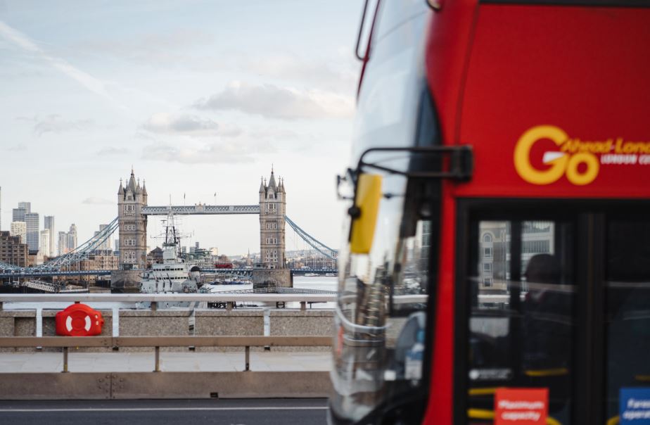 A London bus driving past Tower Bridge